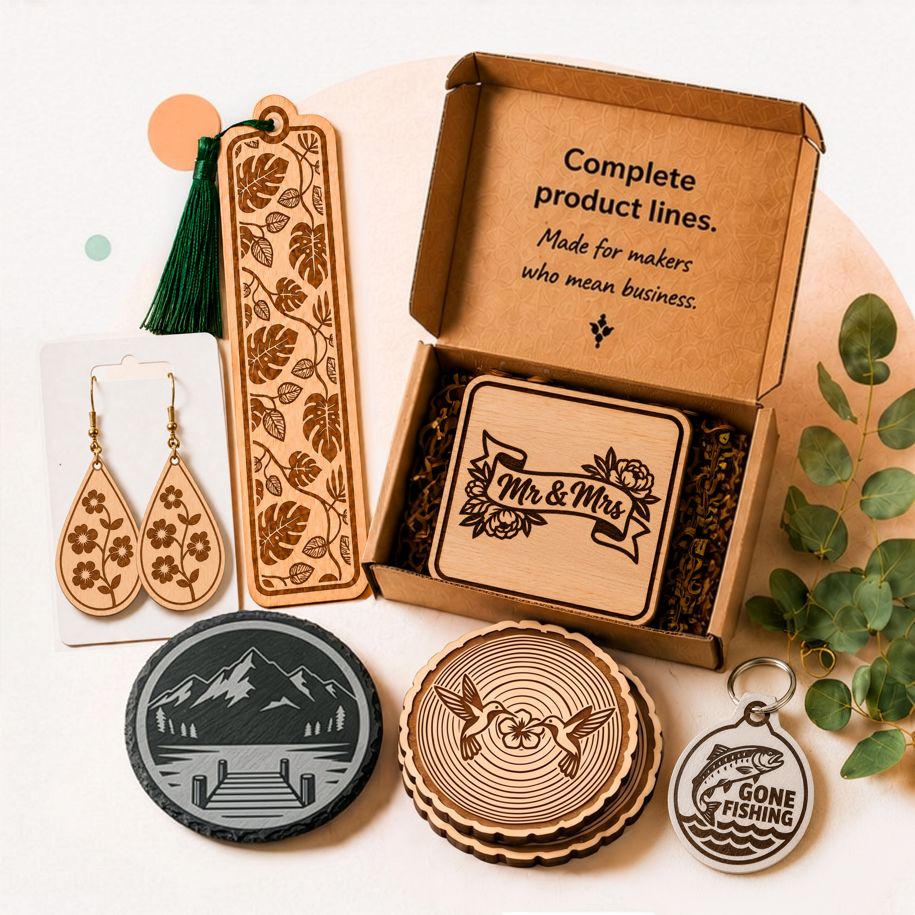 A complete matched collection of finished laser-cut wood products from one Creative Meadow Pro collection — earrings, a bookmark, coasters, a Mr & Mrs gift coaster, and a keychain, arranged together ready to gift or sell.